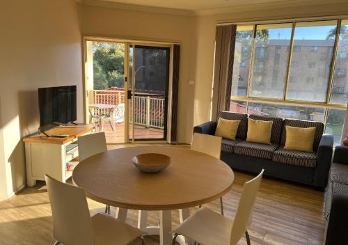 a living room with a table and chairs and a couch at Holiday Paradise - FIFTEEN Marty's @ Little Beach in Nelson Bay