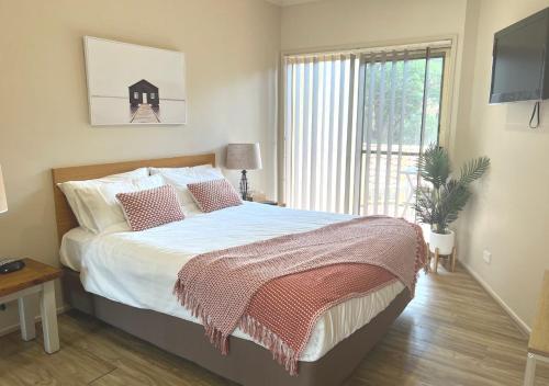 a bedroom with a large bed and a window at Holiday Paradise - FIFTEEN Marty's @ Little Beach in Nelson Bay