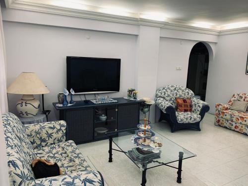 sala de estar con 2 sillas y TV en Luxury House by the Sea Marmaris, en Marmaris