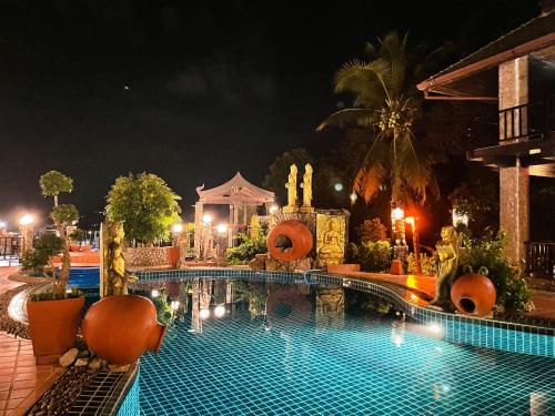 a swimming pool at night in a resort at Boomerang Village Resort Kata in Kata Beach
