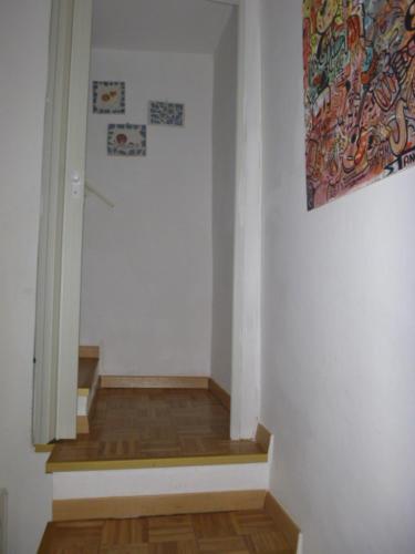 a hallway with white walls and wooden floors and a painting at La Terrazza Sul Borgo -Appartamento- in Cassano delle Murge