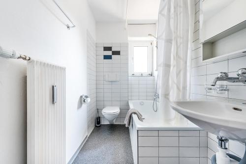 a white bathroom with a sink and a toilet at Cooldis 9 !Gratis Parken, Free Parking! in Kreuzlingen
