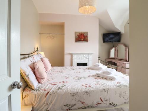 a bedroom with a large bed and a fireplace at Artro View in Llanbedr