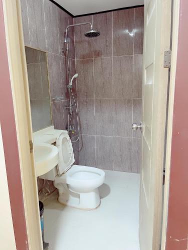 a bathroom with a toilet and a sink at Jun and Helen Hotel and Restaurant in Angeles
