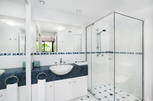 a bathroom with a glass shower and a sink at Club Wyndham Cairns in Cairns