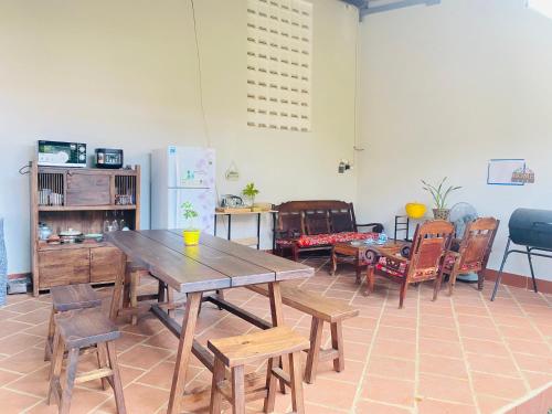 - une salle à manger avec une table et des chaises en bois dans l'établissement PaPa Coffee & Homestay, à Xã Tân Phát