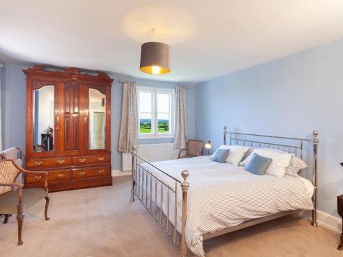 a bedroom with a bed and a wooden dresser at Crablake Farmhouse in Exeter