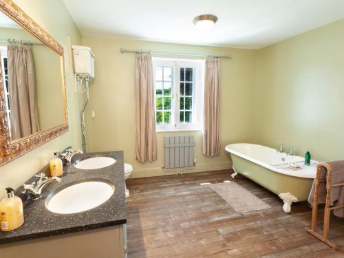 a bathroom with two sinks and a bath tub at Crablake Farmhouse in Exeter