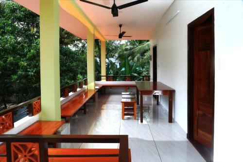 d'un balcon avec des bancs en bois et une table. dans l'établissement Munroe Vision Panakkattu Homestay, à Munroe Island