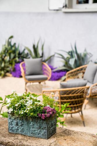 a room with chairs and a table with flowers at La Maison Jaffran, suite en ville in Privas