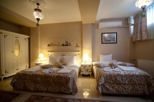 Habitación de hotel con 2 camas y 2 lámparas en Safran Suites, en Estambul