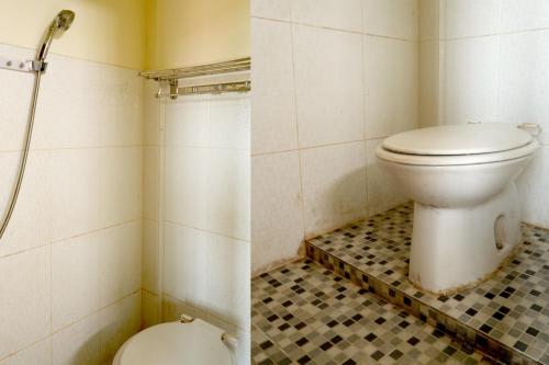 a bathroom with a toilet and a tiled floor at OYO Life 92632 Kost Pondok Kito in Jambi