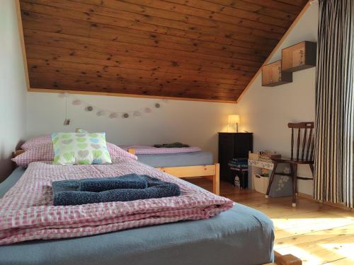 a bedroom with a bed and a wooden ceiling at Kenderhordó Pihenőház in Zánka