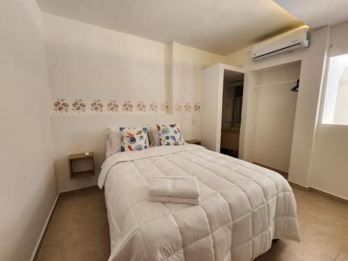 een slaapkamer met een wit bed en een raam bij Apartment in Castillogrande in Cartagena