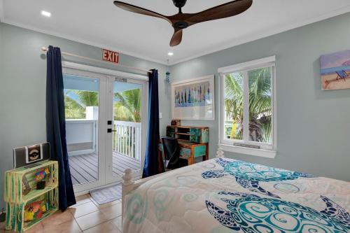 - une chambre avec un lit et un ventilateur de plafond dans l'établissement Casa Blue Pelican., à Marathon