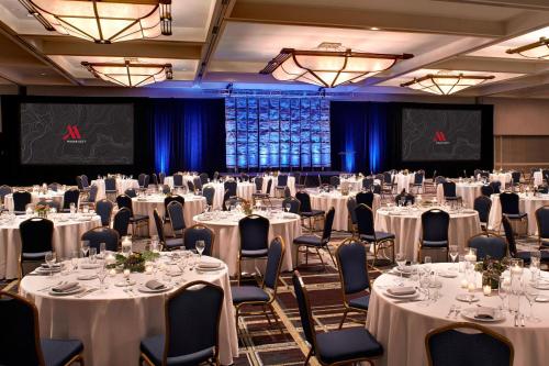 a ballroom with white tables and chairs and a stage at Detroit Marriott at the Renaissance Center in Detroit