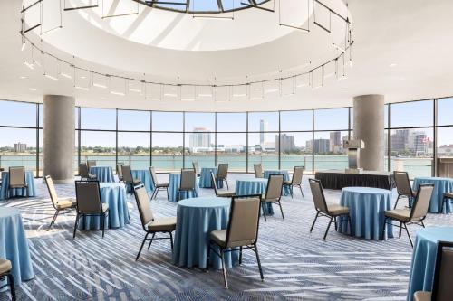 a large room with tables and chairs and a large chandelier at Detroit Marriott at the Renaissance Center in Detroit
