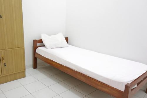 łóżko w pokoju z poduszką w obiekcie OYO Life 92925 Kost Bu Mala 2 Syariah w mieście Pasuruan