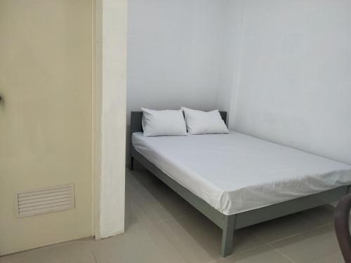 ein Bett mit zwei Kissen auf einem Zimmer in der Unterkunft OYO Life 93054 Th Residence 135 Syariah in Medan