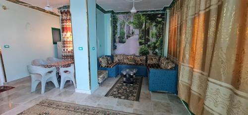 uma sala de estar com um sofá, uma mesa e cadeiras em The Green Nubian House em Aswan