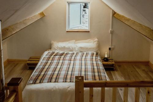 a bedroom with a bed with a plaid blanket at The Calf House in Borrisoleigh