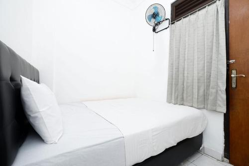 un letto bianco in una stanza con finestra di OYO Life 1942 Asia Residence Syariah a Semarang