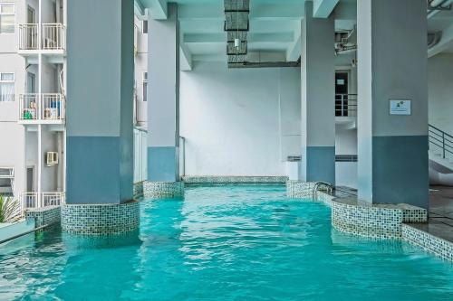 ein Pool in einem Gebäude mit blauem Wasser in der Unterkunft Collection O 91566 Edurent Bandung in Sayang