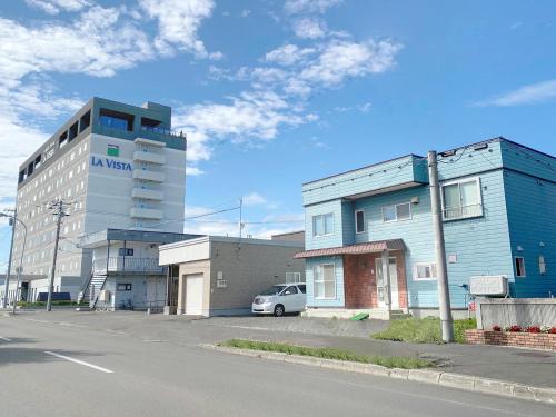 a building on the side of a street next to a building at Furano House, JR Station, 2F Apartment, 3 Bedrooms, Max 8PP - 6 Adults 2 Kid, Onsite Parking in Furano
