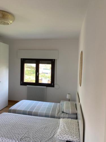 1 dormitorio blanco con 2 camas y ventana en Film festival bedroom, en Lido de Venecia
