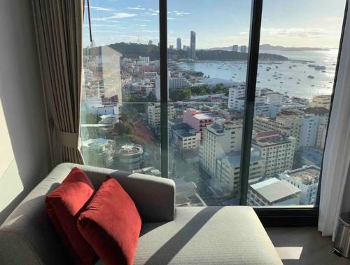 a room with a couch in front of a large window at The Edge Central Pattaya Seaview in Pattaya