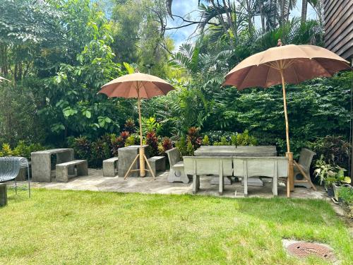 deux parapluies, une table et des chaises et une sidx sidx sidx sidx dans l'établissement Chern Chiangmai Boutique Hotel, à Chiang Mai