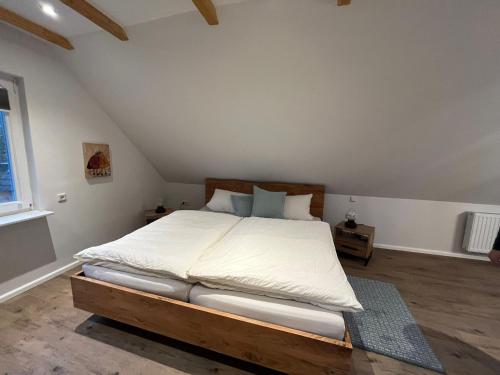 a bedroom with a large bed in a attic at Amei's Huuske Wohnung Amelie in Krummhörn