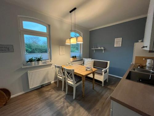 a kitchen and dining room with a table and chairs at Amei's Huuske Wohnung Tomma EG in Krummhörn