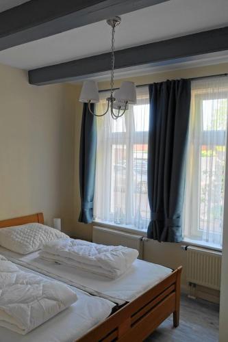 a bedroom with two beds and two windows at Wohnung Geelina EG in Krummhörn
