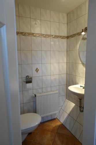 a bathroom with a toilet and a sink at Wohnung Geelina EG in Krummhörn