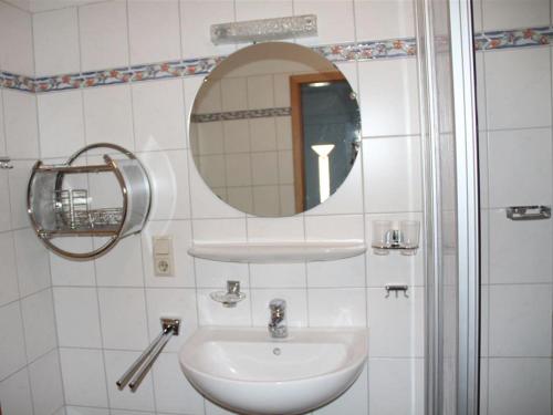 ein Bad mit einem Waschbecken und einem Spiegel in der Unterkunft Wohnung Küstenperle in Krummhörn