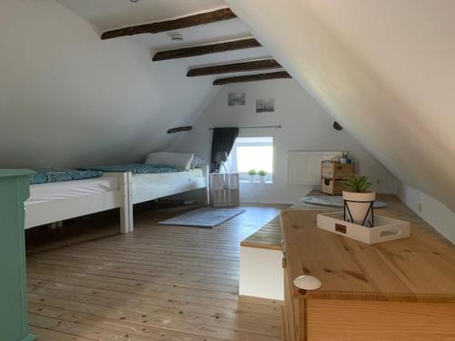 a room with two beds and a table in it at Haus Lüttje Huus an't Diek in Krummhörn