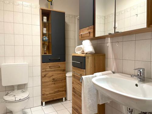 uma casa de banho branca com um lavatório e um WC em Strandläufer Nr 7 em Cuxhaven