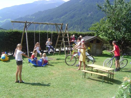 a group of people playing in a park with a swing at Apart Tyrol in Uderns