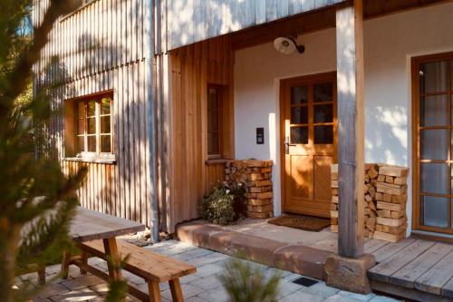 un porche de una casa con una puerta de madera y un banco en Das Heuhaus, 
