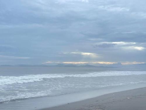 a beach with the ocean and a cloudy sky at Loft Mágico en Nativa Resort in Tarcoles