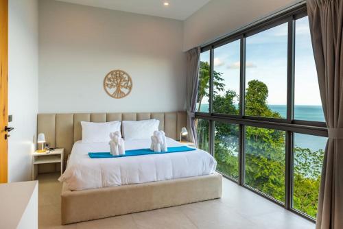 a bedroom with a bed with a view of the ocean at Villa CholChalee - Amazing View in Amphoe Koksamui