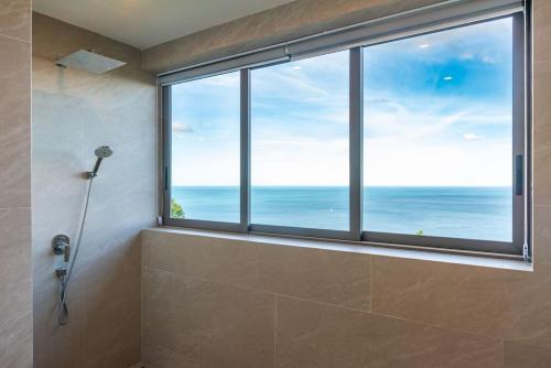 a bathroom with a shower with a view of the ocean at Villa CholChalee - Amazing View in Amphoe Koksamui