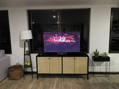 a flat screen tv sitting on a stand in a living room at Loft Mágico en Nativa Resort in Tarcoles