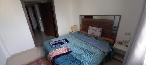 Schlafzimmer mit einem Bett und einem Spiegel in der Unterkunft Dar Othman in Akouda