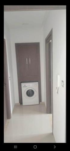 eine Waschmaschine und einen Trockner in einem weißen Zimmer mit einer Tür in der Unterkunft Dar Othman in Akouda