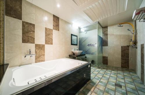 a large bathroom with a tub and a sink at Hotel Kobos in Ulsan