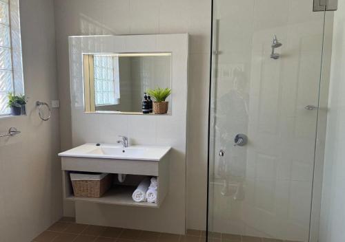 a bathroom with a sink and a glass shower at Holiday Paradise - FIFTEEN Marty's @ Little Beach in Nelson Bay