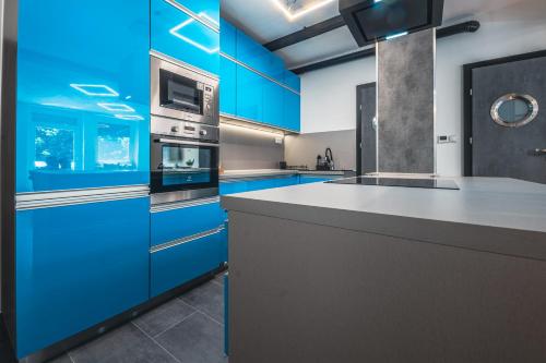 a kitchen with blue cabinets and a stove top oven at Unique in Eger