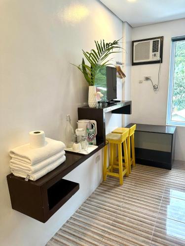 a room with a desk with a microwave and a kitchen at DENGI INN EL NIDO in El Nido